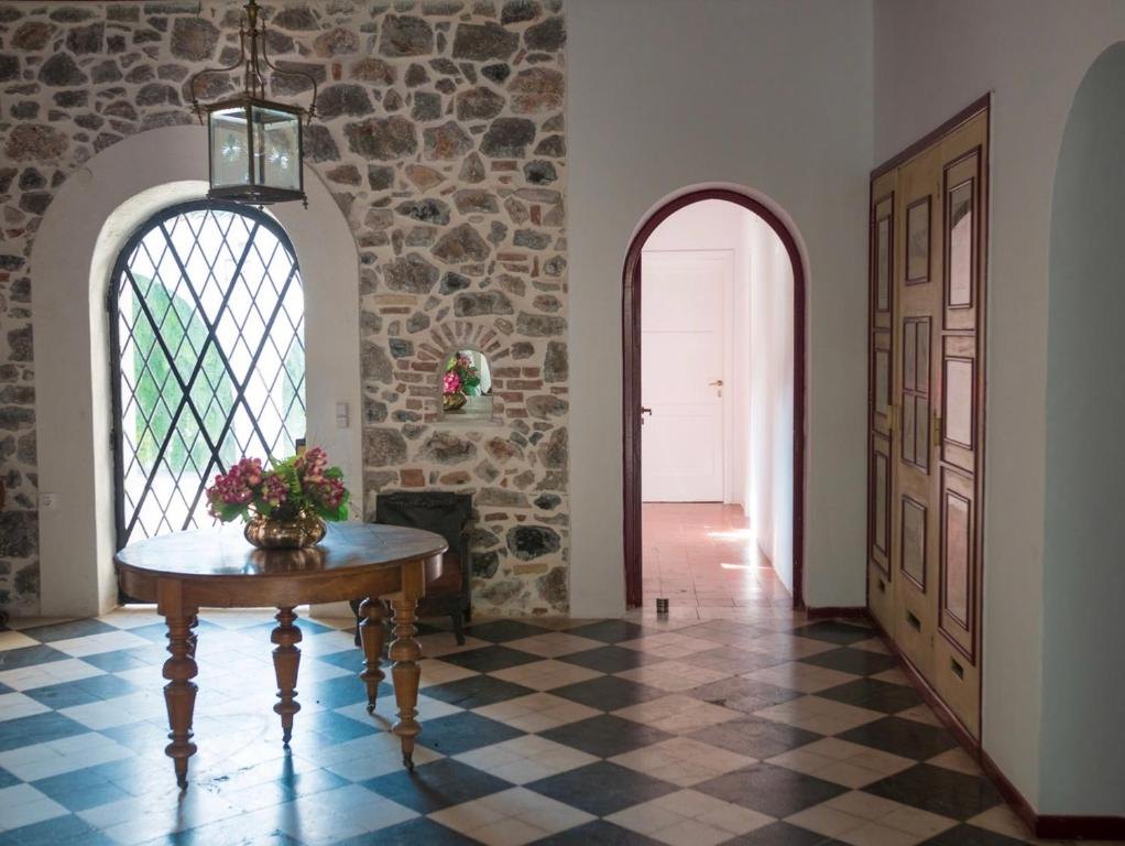 The entrance hall with its stone arch and checkerboard floor