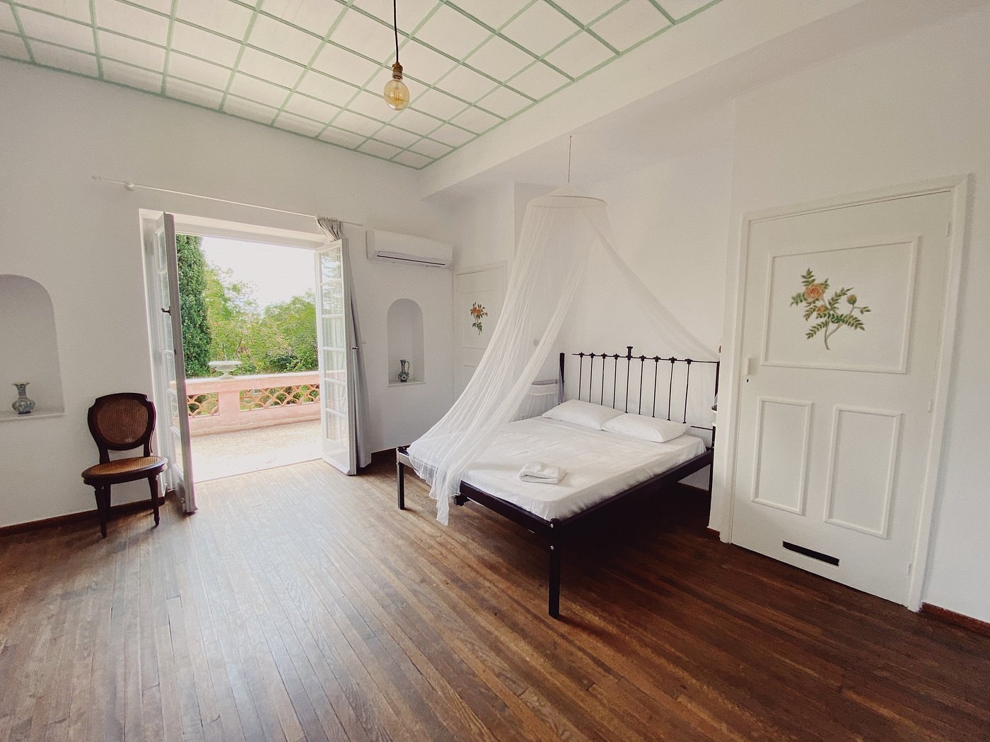A bedroom with canopy bed and terrace doors
