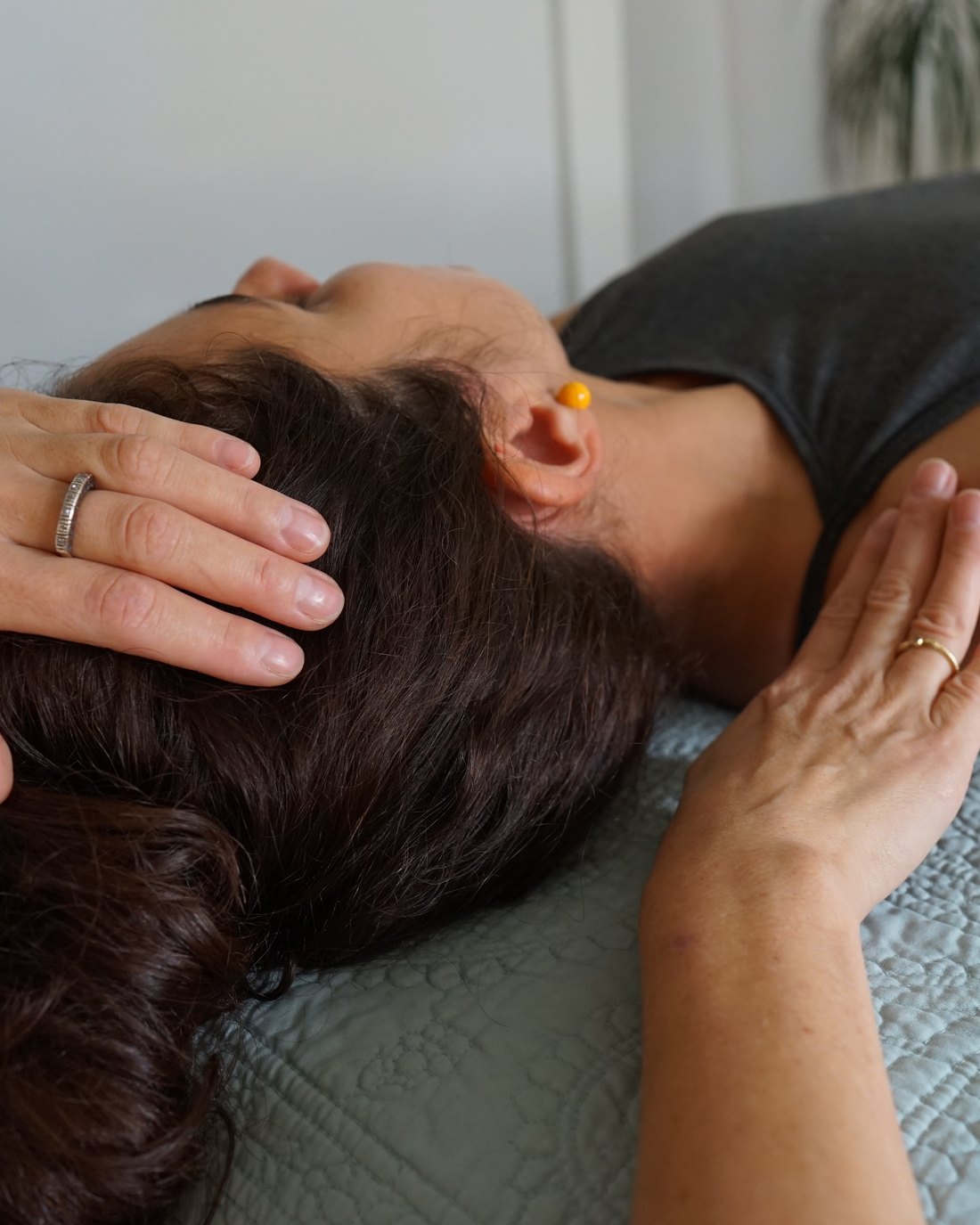 Hands supporting the head and shoulder during a somatic session
