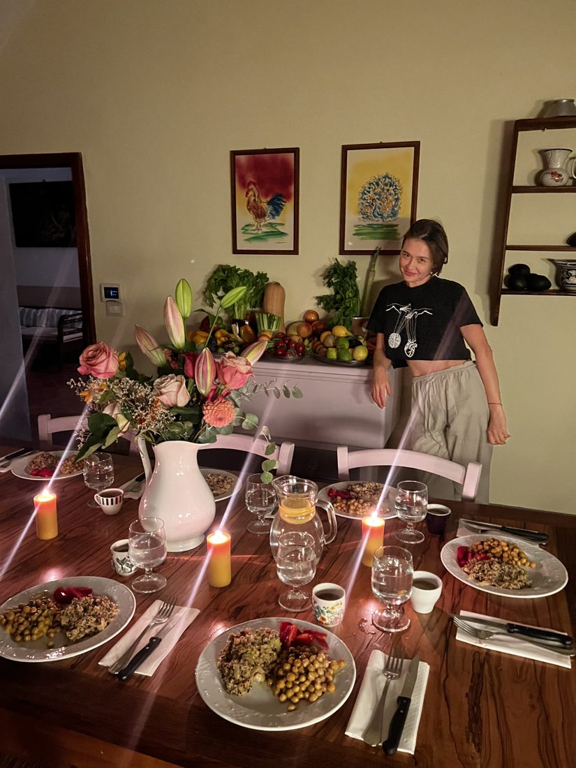 Alexandra beside the dinner table laid with candles, flowers and Ayurvedic plates
